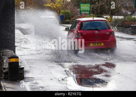 Autofahrer zu schnell gefahren durch grosse Pfützen einweichen Fußgänger und Unterkunft in Ambleside, Cumbria, Großbritannien. Stockfoto