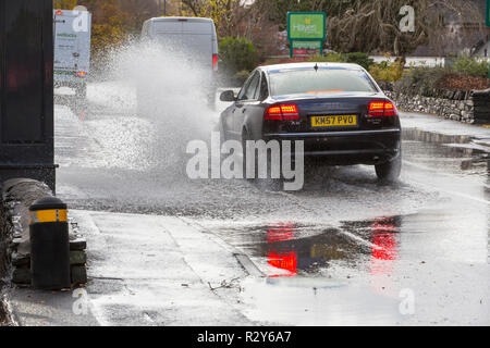 Autofahrer zu schnell gefahren durch grosse Pfützen einweichen Fußgänger und Unterkunft in Ambleside, Cumbria, Großbritannien. Stockfoto