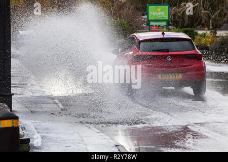 Autofahrer zu schnell gefahren durch grosse Pfützen einweichen Fußgänger und Unterkunft in Ambleside, Cumbria, Großbritannien. Stockfoto