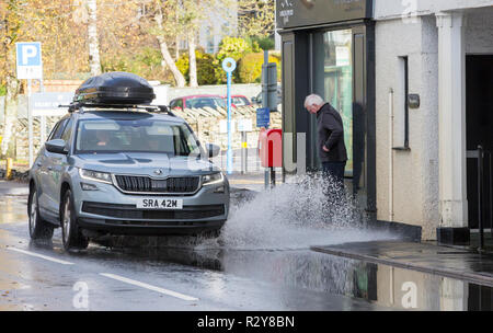 Autofahrer zu schnell gefahren durch grosse Pfützen einweichen Fußgänger und Unterkunft in Ambleside, Cumbria, Großbritannien. Stockfoto