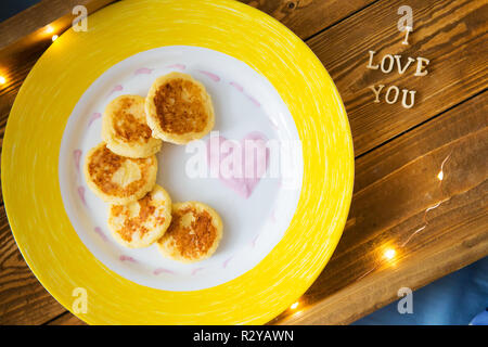 Käse Pfannkuchen auf einem Tablett - Frühstück im Bett, die Inschrift ich liebe Dich, close-up. Stockfoto