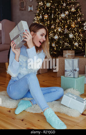 Fröhliches Mädchen finden ein Haufen Geschenke unter dem Weihnachtsbaum Stockfoto