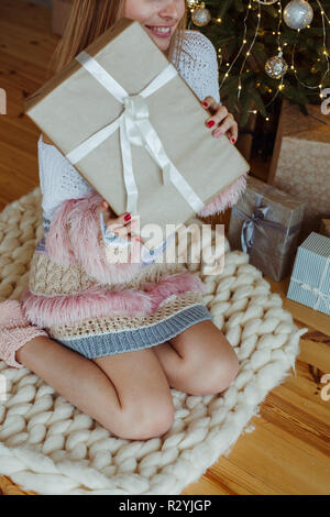Fröhliches Mädchen finden ein Haufen Geschenke unter dem Weihnachtsbaum Stockfoto