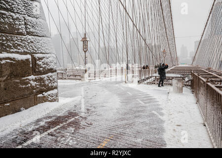 Brooklyn Bridge bei Schneesturm, ein Blick auf Manhattan Gebäude im Nebel Stockfoto