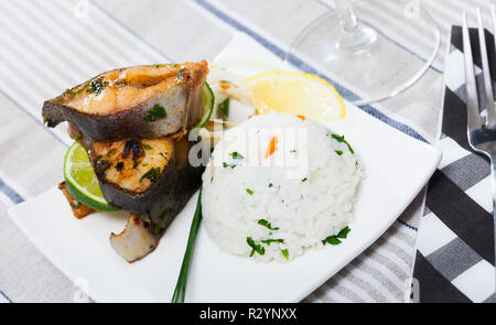 Ofen gebackene Forellen Steaks serviert mit Reis und Zitrone Stockfoto