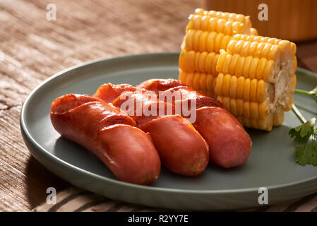 Home gegrillte Würstchen auf einem dunklen Platte, ein Fleischgericht auf einem dunklen Hintergrund, heiße Würstchen mit Gewürzen und Salz in einer Küche zu Hause, kopieren Sie Raum, Tropfen Stockfoto