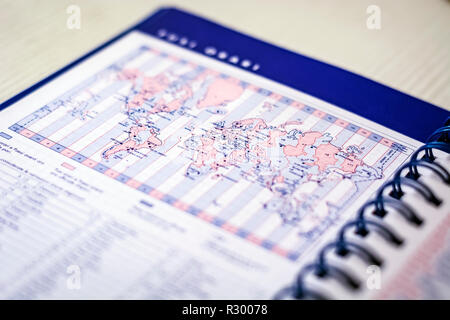 Spirale Tagebuch auf der Seite mit der Weltkarte mit Zeitzonen. Geschäft und Welt reisen Stockfoto