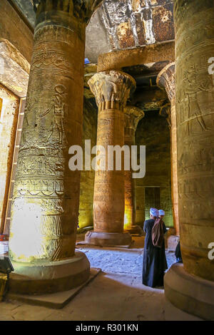 Zwei arabische Männer in traditioneller Kleidung suchen an den Säulen, Tempel von Edfu, einem ägyptischen Tempel entfernt auf dem Nil in Edfu, Ägypten, Nordafrika Stockfoto