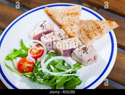 Fisch und Meeresfrüchte. Thunfisch Steaks mit Sesam bestreut mit Garnierung des frischen Grüns und gegrillte Brotscheiben Stockfoto