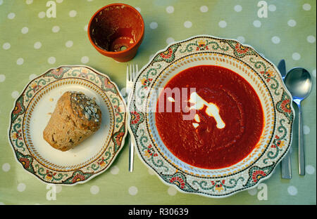 Mit Blick auf China Schüssel Tomatensuppe mit Sahne und braunes Brot, gebacken in Ton Blumentopf. Stockfoto