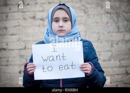 Flüchtling Mädchen mit einer Inschrift auf einem weißen Blatt' ich essen wollen" Stockfoto