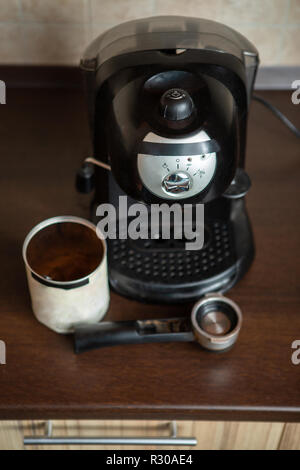 Foto von Kaffeemaschine, Becher, Löffel am Tisch Stockfoto