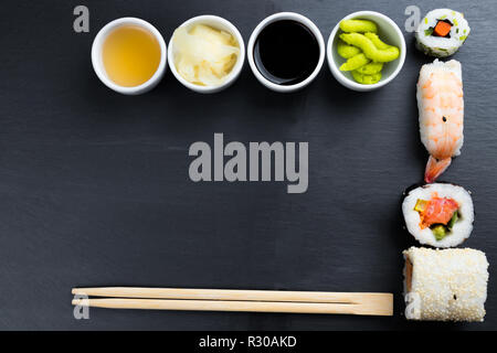 Typische asiatische Küche auf schwarze Küche Schiefer. Ingwer, Japanische Meerrettich Wasabi, Soja- und Fischsauce in kleinen weißen Schalen. Stäbchen. Sush Stockfoto