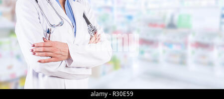 Frau Doktor stehend über verschwommenes Apotheke Interieur. Stockfoto
