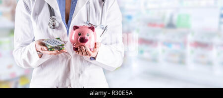 Arzt frau Hände halten Pillen und Sparschwein. Verschwommen Apotheke Innenraum im Hintergrund. Stockfoto