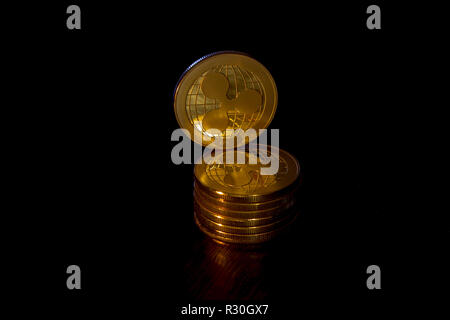 Crypto Währung welligkeit Goldmünzen auf schwarzem Hintergrund. Zusätzlich zu den liegenden Münzen, es gibt ständige Welligkeit. Stockfoto