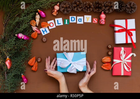 Women's Händen halten Geschenk Weihnachtsbaum Weihnachten Neujahr/Hintergrund Stockfoto