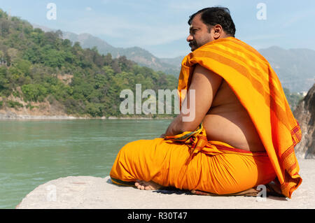 Ein Mönch Meditieren entlang des Flusses Ganges. Rishikesh, Indien Stockfoto