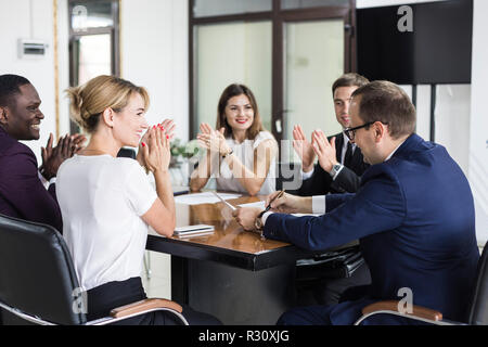Multirassischen junge kreative Menschen in modernen Büro. Sind eine Gruppe von jungen Geschäftsleuten zusammen mit Laptop, Tablet-PC, Smartphone, Notebook. Stockfoto