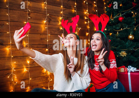 Zwei beste Freunde, die selfie im Schlafzimmer in der Nähe von Weihnachten Baum Stockfoto