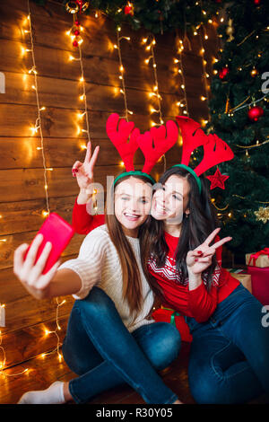Zwei beste Freunde, die selfie im Schlafzimmer in der Nähe von Weihnachten Baum Stockfoto