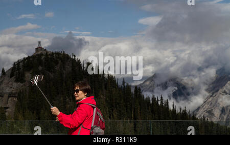 Ein Tourist, der eine selfie in der Kanadischen Rockies mit einem selfie Stick. Stockfoto