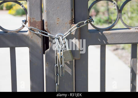 Ein Metalltor durch Ketten und einem Schloss gesichert. Stockfoto