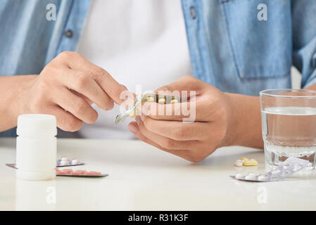 Mann Pille, die aus der Blisterpackung zu Hause Stockfoto