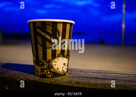 Papier Kaffeetasse, Meer Hintergrund, früh dunkel, Kaffee am Morgen vor Sonnenaufgang Stockfoto