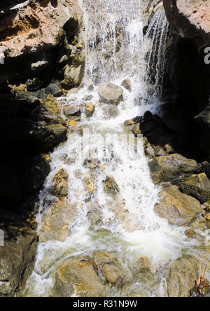 Wasser in der Zeit über goldenen Felsen eingefroren. Stockfoto