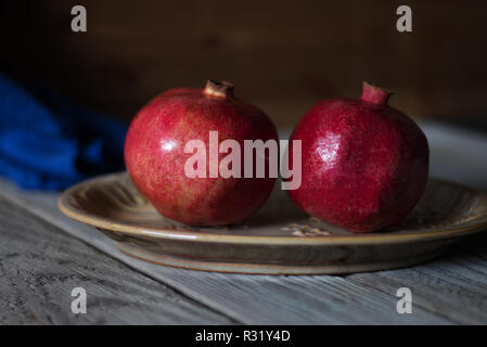 Zwei Granatäpfel in einer Schale Stockfoto