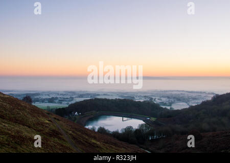Sonnenaufgang auf einem eisigen Wintern, nebligen Morgen. Auf der Suche nach einem Behälter über die englische Landschaft. Malvern Hills. Stockfoto