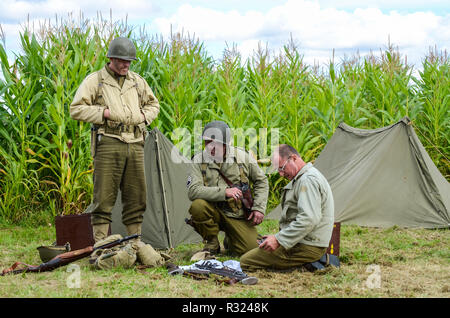 Wiederaufbau der US-Armee im Zweiten Weltkrieg. Reenactors in alter Kampfkleidung mit Zelt und Ausrüstung Stockfoto