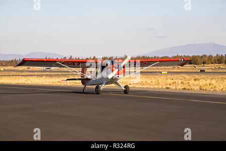 Ein Pilot zieht aus einem kleinen Flughafen in Bend, Oregon, in seinem 1997 Aviat Husky Flugzeug. Stockfoto