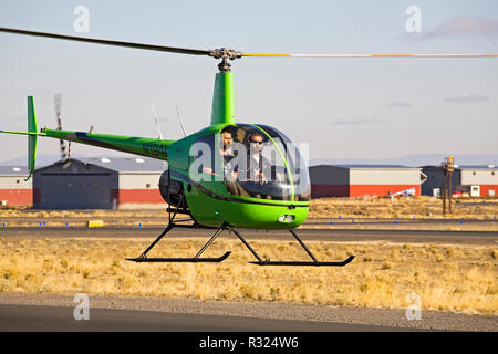 Ein Ausbilder und Flugschüler fliegen zwei - Sitz R22 Beta II Hubschrauber durch die Robinson helicopter Company, in einer kleinen Stadt Flughafen in Bend, Oregon Stockfoto