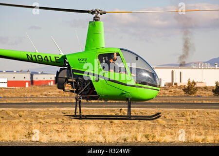 Ein Ausbilder und Flugschüler fliegen zwei - Sitz R22 Beta II Hubschrauber durch die Robinson helicopter Company, in einer kleinen Stadt Flughafen in Bend, Oregon Stockfoto