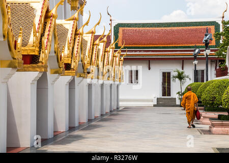 Ein buddhistischer Mönch in orangefarbene Gewänder Spaziergänge Vergangenheit Wat Ratchanadda, Bangkok. Die 37 all-metal Türme die 37 Tugenden, die zur Erleuchtung führen symbolisieren Stockfoto