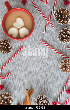 Heißer Kakao mit Marshmallows, Zuckerstangen und kiefernzapfen Weihnachten flach Stockfoto