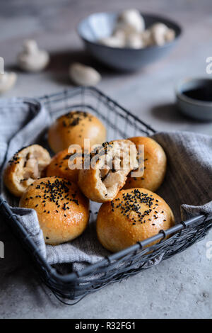 Gebackene Brötchen gefüllt mit Pilzen und Käse, verziert mit schwarzer Kreuzkümmel Stockfoto