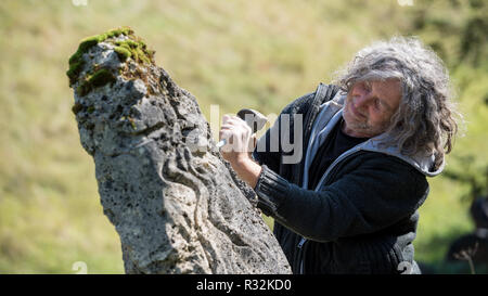 Männliche Bildhauer Carving in Stein außerhalb an einem sonnigen Tag. Stockfoto