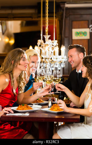 Freunde in einem sehr guten Restaurant stoßen Stockfoto