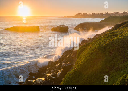 Die Wellen brechen an der felsigen Küste bei Sonnenuntergang, Santa Cruz, Kalifornien Stockfoto