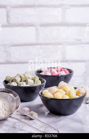 Frisch Gnocchi mit Kopie Raum gesehen von oben. Frische hausgemachte Kartoffel, Spinat und Zuckerrüben Knödel bereit für das Kochen. Vegan italienische Küche. Stockfoto