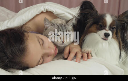 Schöne jugendlich Mädchen süß schlafen im Bett mit Hund und Katze Stockfoto