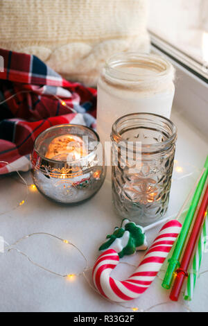 Still life Details mit Kerzen, Spielzeug Zuckerstange und Girlande. Skandinavische hygge Konzept, Weihnachten und das neue Jahr noch Leben Stockfoto