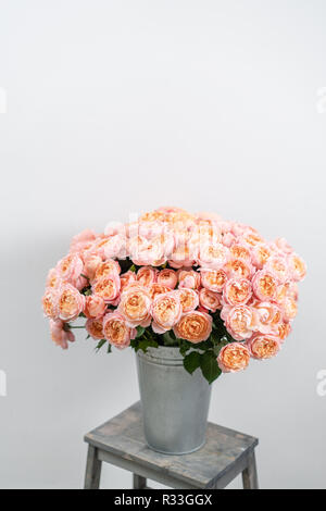 Großen Luxus helle Blumenstrauß peony Rose auf Holztisch. Garten spray Rosen rosa und Pfirsich Farbe. Blumenstrauß in Vase aus Metall Stockfoto