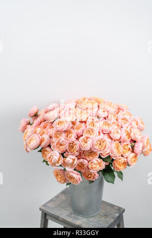 Großen Luxus helle Blumenstrauß peony Rose auf Holztisch. Garten spray Rosen rosa und Pfirsich Farbe. Blumenstrauß in Vase aus Metall Stockfoto