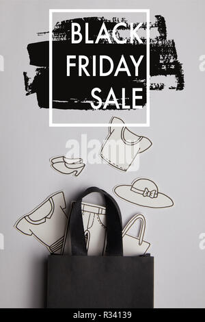 Ansicht von oben schwarz Einkaufstasche und Papier Kleidung auf grauem Hintergrund, schwarzer Freitag verkauf Konzept Stockfoto