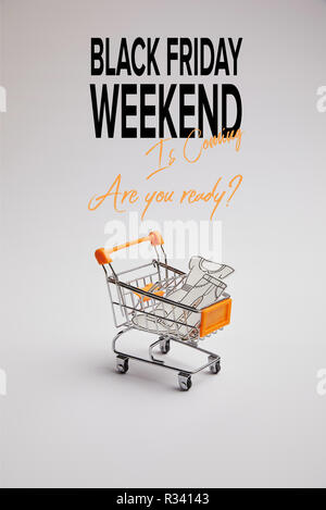 Nahaufnahme der Warenkorb mit wenig Waren aus Papier auf grauem Hintergrund, schwarzer Freitag Wochenende Inschrift Stockfoto