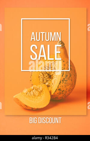 Nahaufnahme der Schneiden rohe Kürbis mit Herbst Sale Inschrift auf orangefarbenem Hintergrund Stockfoto